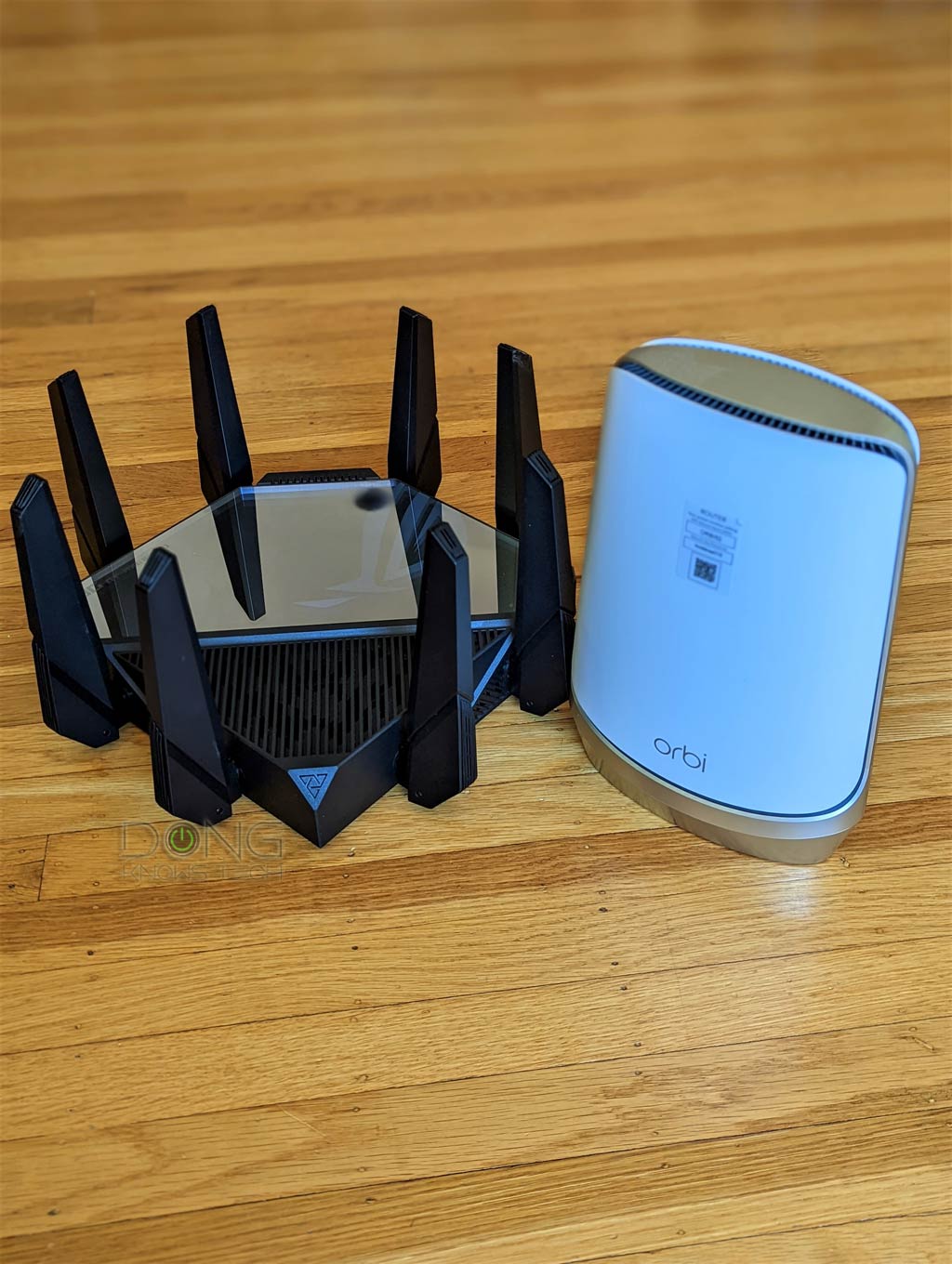 Asus GT-AXE16000 vs. Netgear Orbi RBKE960: The Asus router is much bulkier than the Netgear counterpart.